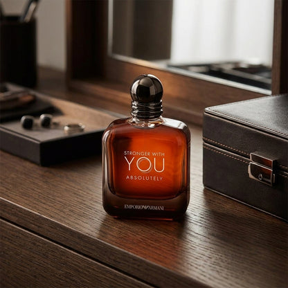 Emporio Armani Stronger With You Absolutely Parfum bottle on dark oak wood table lifestyle scene
